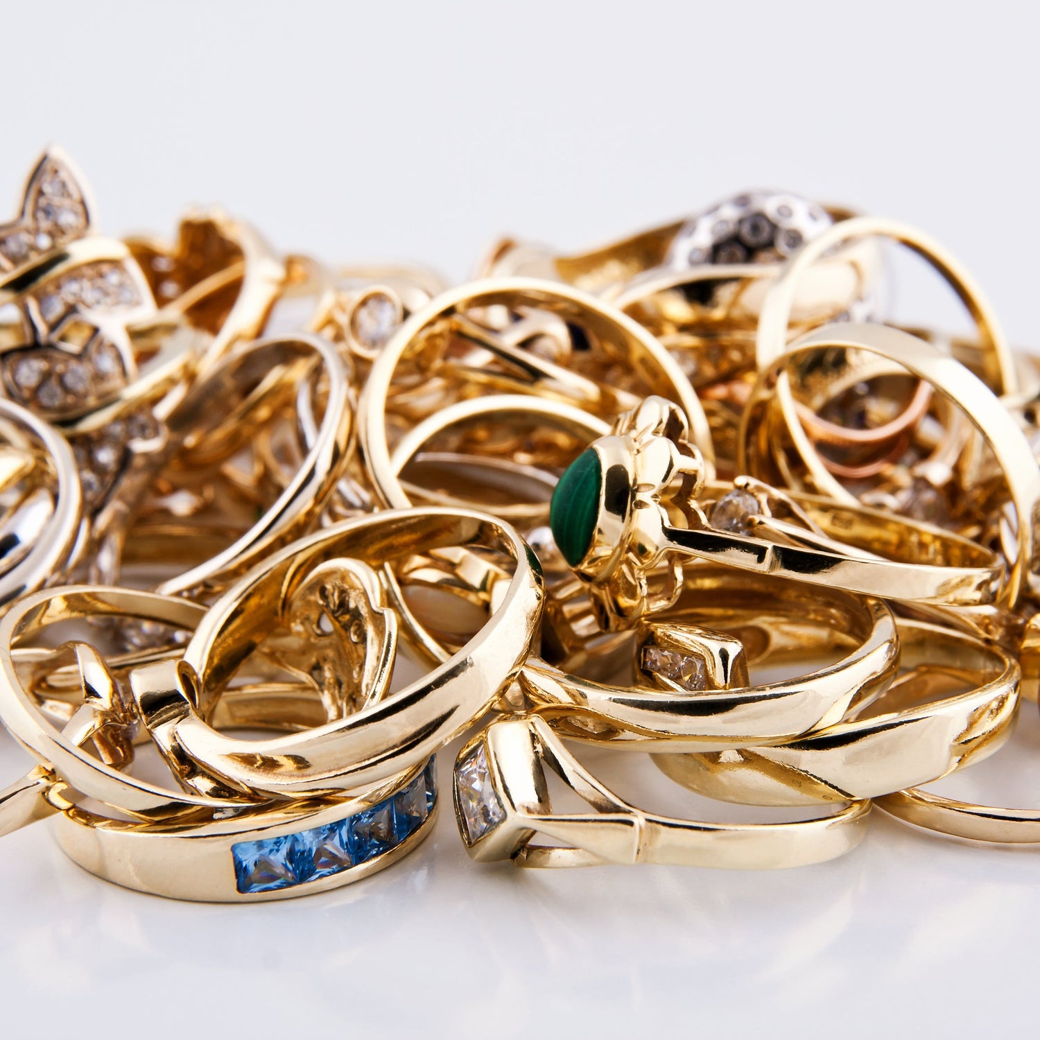 Collection of gold rings with various designs on a white background